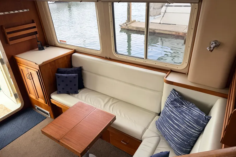 Slide: The Image of Cozy interior of 2002 American Tug 34 with white seating and nautical decor. - 8