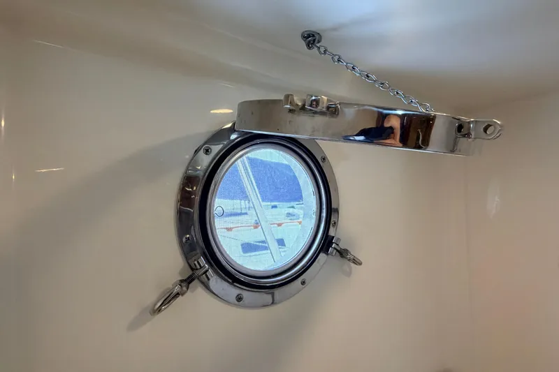 Slide: The Image of Open porthole on 2002 American Tug 34, showcasing nautical design details. - 80
