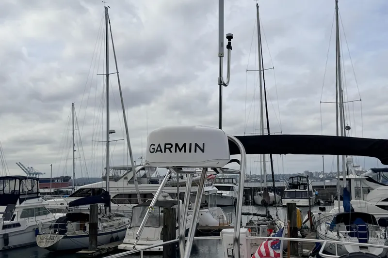 Slide: The Image of American Tug 34 (2002) with Garmin equipment docked in a marina, surrounded by sailboats. - 90