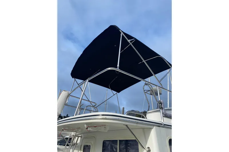 Slide: The Image of American Tug 34 (2002) with a blue canopy against a cloudy sky. - 92