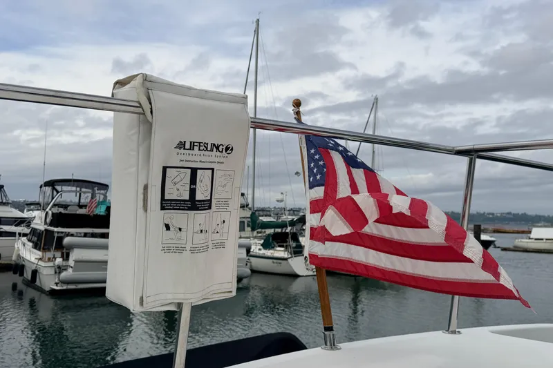 Slide: The Image of American Tug 34 (2002) with Lifesling rescue system and American flag at marina. - 93