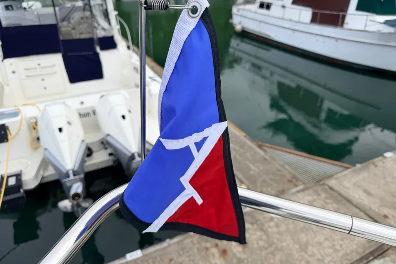 Slide: The Image of Flag on American Tug 34, 2002 model, docked near other boats. - 95