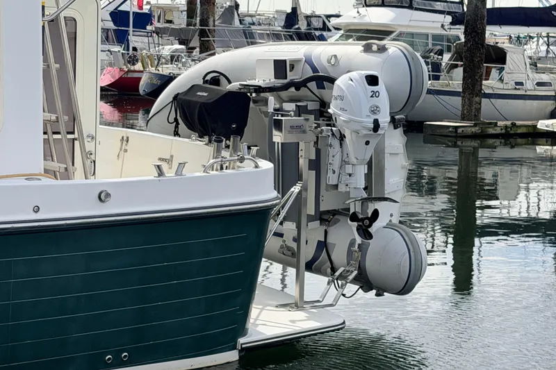 Slide: The Image of American Tug 34 (2002) with outboard motor and dinghy at marina. - 96