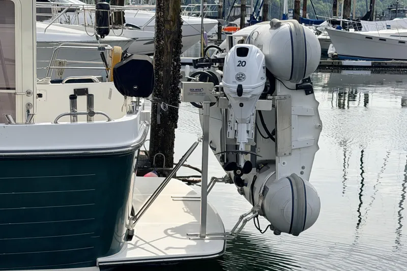 Slide: The Image of American Tug 34 (2002) with outboard motor and dinghy at marina. - 97