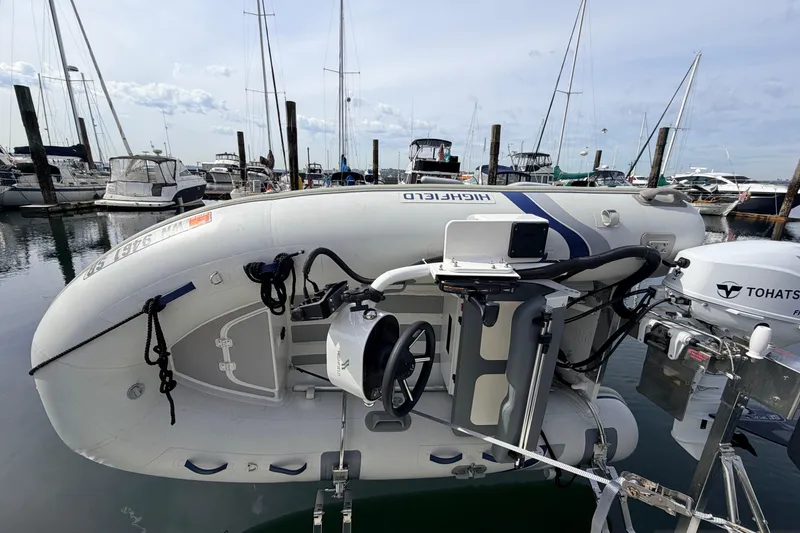 Slide: The Image of Inflatable boat with Tohatsu motor docked near American Tug 34, 2002 model. - 98