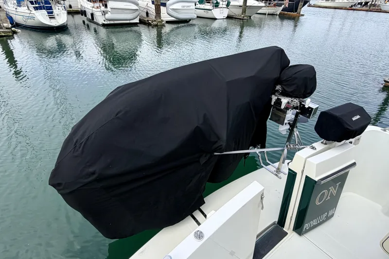 Slide: The Image of Covered outboard motor on a 2002 American Tug 34 at a marina. - 99