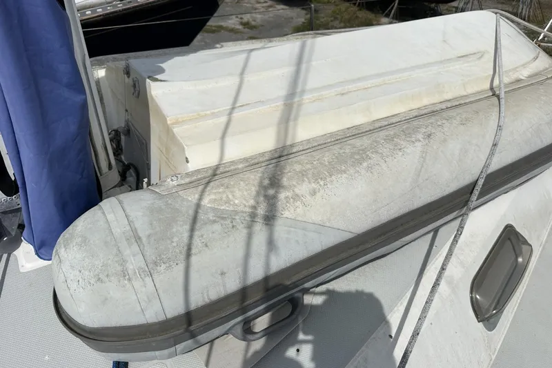 Slide: The Image of Deck of 1991 Catalina 42 sailboat with inflatable dinghy and blue cover. - 111