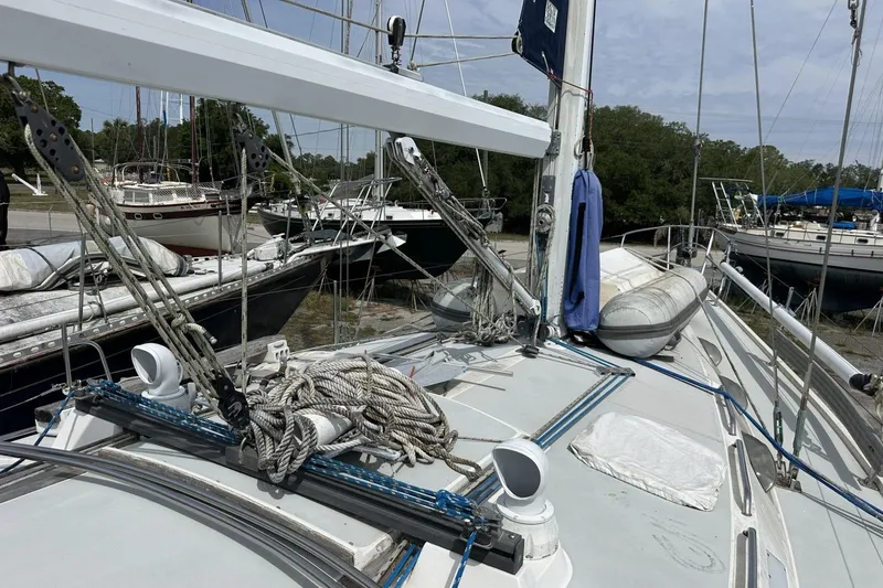 Slide: The Image of 1991 Catalina 42 sailboat deck with ropes and equipment in a marina setting. - 118
