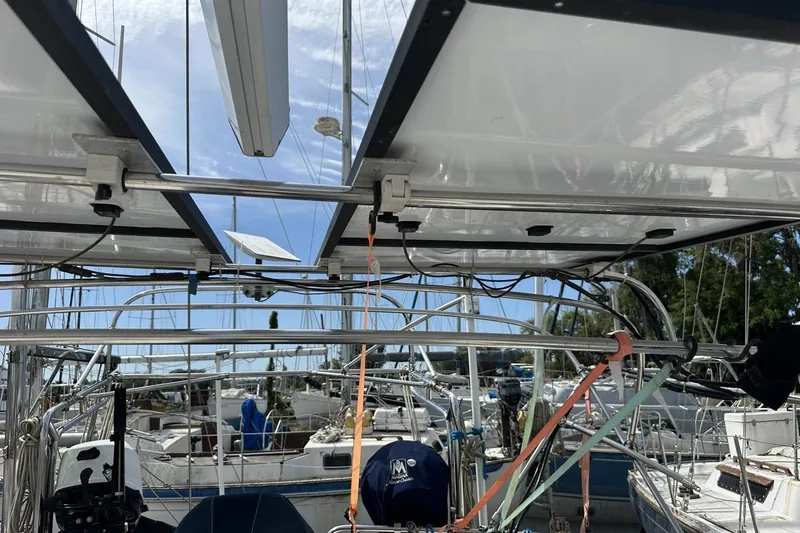 Slide: The Image of Cockpit view of a 1991 Catalina 42 sailboat with solar panels and marina background. - 122