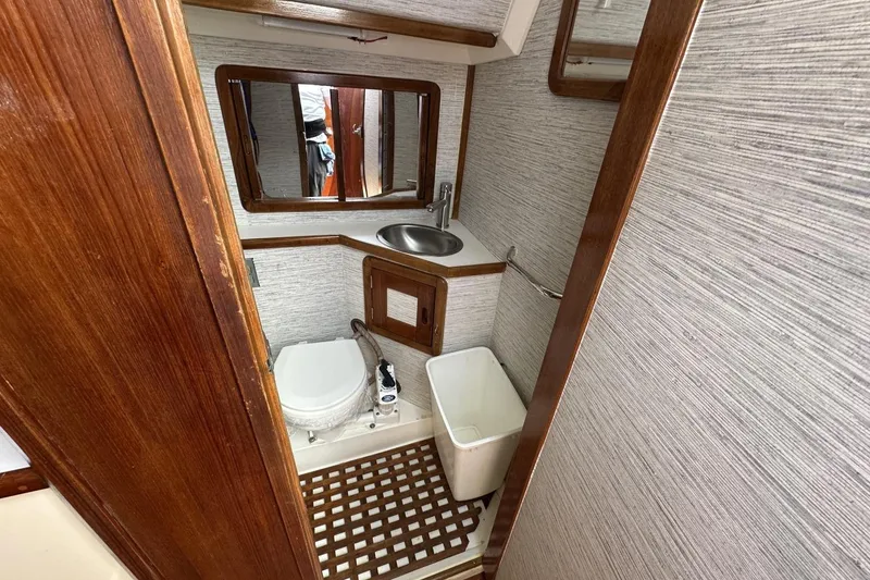 Slide: The Image of Bathroom interior of a 1991 Catalina 42 sailboat with wooden accents and compact design. - 13