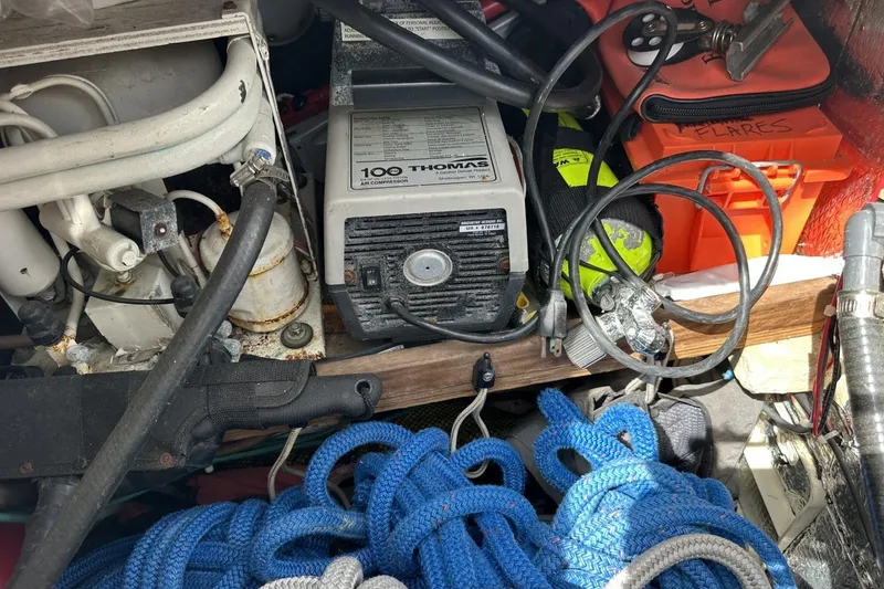 Slide: The Image of Boat equipment storage with air compressor, ropes, and safety gear on a 1991 Catalina 42. - 135