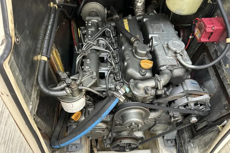 Slide: The Image of Engine compartment of a 1991 Catalina 42 sailboat, showcasing mechanical components and hoses. - 14