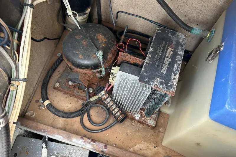 Slide: The Image of Rusty engine compartment of a 1991 Catalina 42 sailboat with wiring and components. - 143