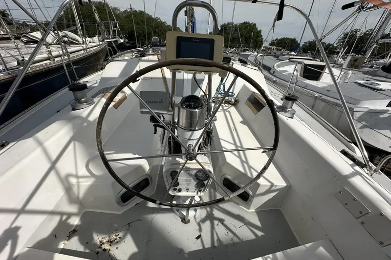 Slide: The Image of Cockpit of a 1991 Catalina 42 sailboat with steering wheel and navigation equipment. - 158