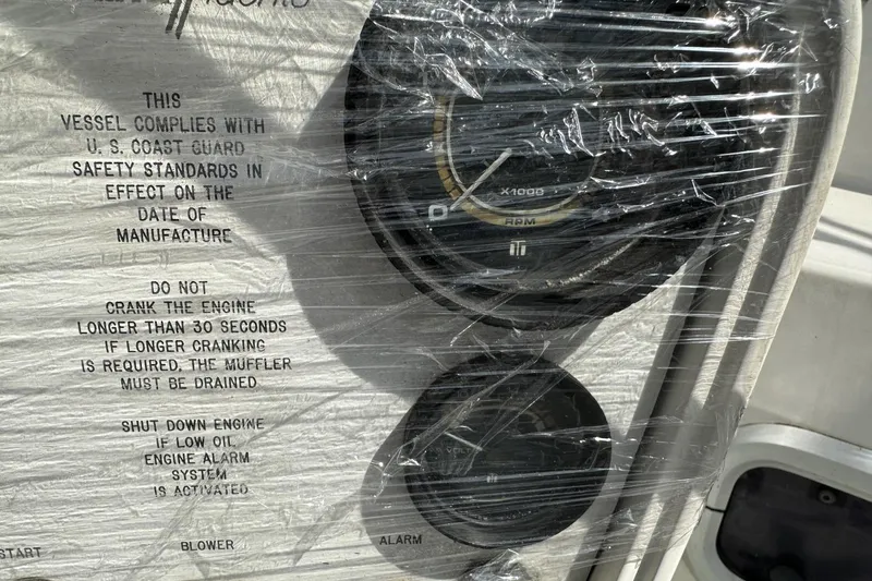Slide: The Image of 1991 Catalina 42 engine panel with safety instructions and RPM gauge. - 172