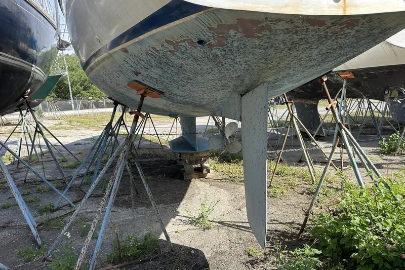 Slide: The Image of 1991 Catalina 42 sailboat hull on stands, showing keel and propeller. - 184