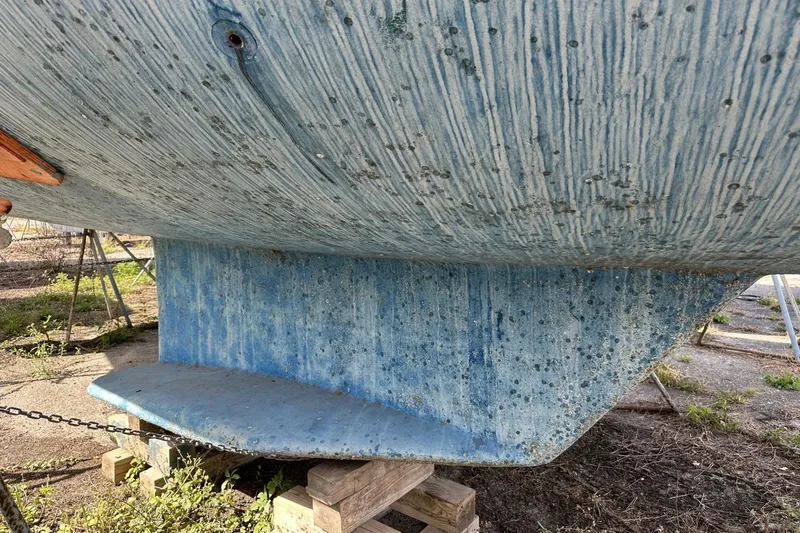 Slide: The Image of Close-up of a 1991 Catalina 42 sailboat hull on wooden blocks. - 191