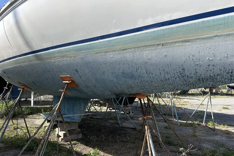 Slide: The Image of 1991 Catalina 42 sailboat hull on stands, undergoing maintenance in a boatyard. - 192
