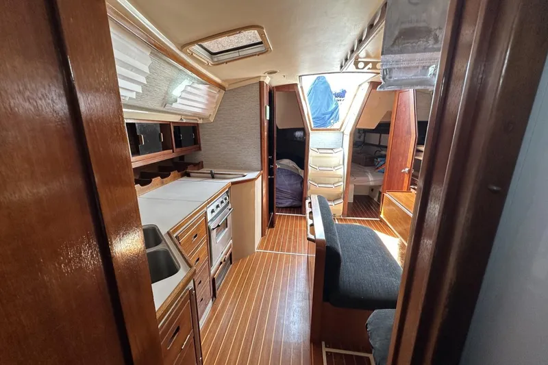 Slide: The Image of Interior of a 1991 Catalina 42 sailboat featuring a cozy kitchen and seating area. - 27