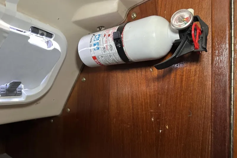 Slide: The Image of Fire extinguisher mounted on wooden panel inside 1991 Catalina 42 boat cabin. - 30