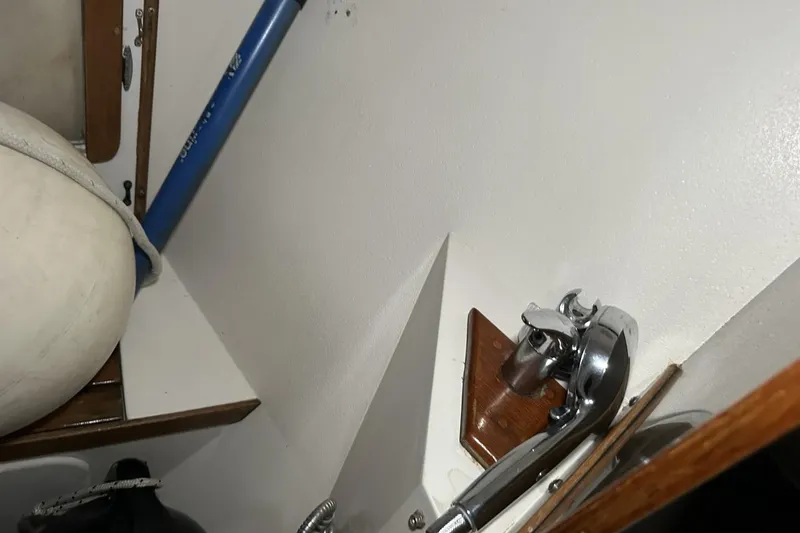 Slide: The Image of Interior of a 1991 Catalina 42 sailboat showing a faucet and storage area. - 32