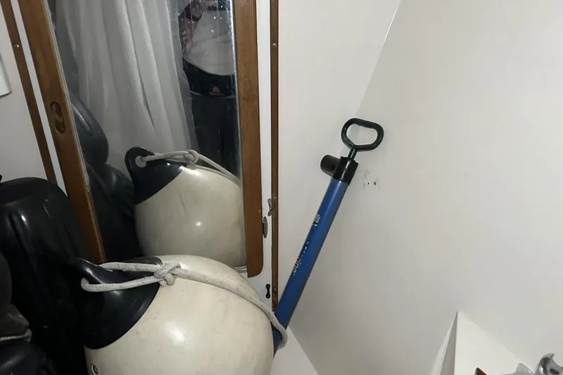 Slide: The Image of Storage area on a 1991 Catalina 42 sailboat with fenders and a manual pump. - 33