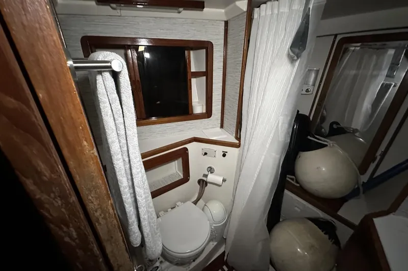 Slide: The Image of Bathroom interior of a 1991 Catalina 42 sailboat with wooden accents and nautical equipment. - 34