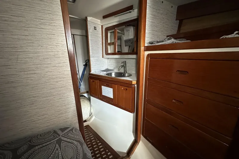 Slide: The Image of Interior of 1991 Catalina 42 sailboat featuring wooden cabinetry and compact sink area. - 36