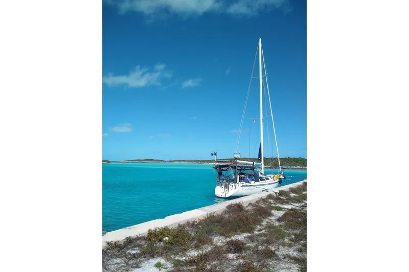 Slide: The Image of Sailboat Catalina 42 (1991) docked by turquoise waters under clear blue sky. - 4