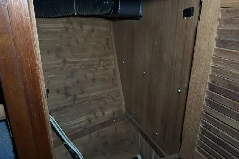 Slide: The Image of Wooden interior of a 1991 Catalina 42 sailboat, featuring paneling and ventilation duct. - 40