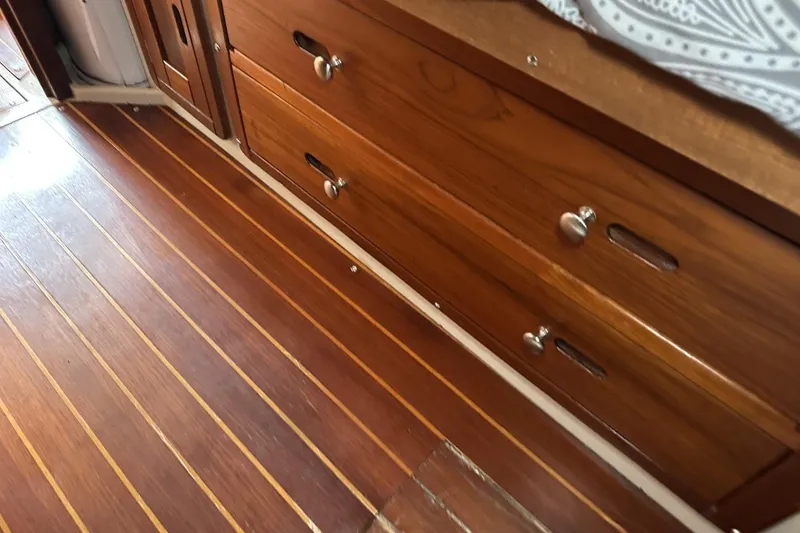 Slide: The Image of Wooden interior of a 1991 Catalina 42 sailboat, featuring polished drawers and flooring. - 45