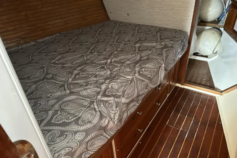 Slide: The Image of Cozy cabin interior of 1991 Catalina 42 sailboat with patterned bedding and wooden flooring. - 48