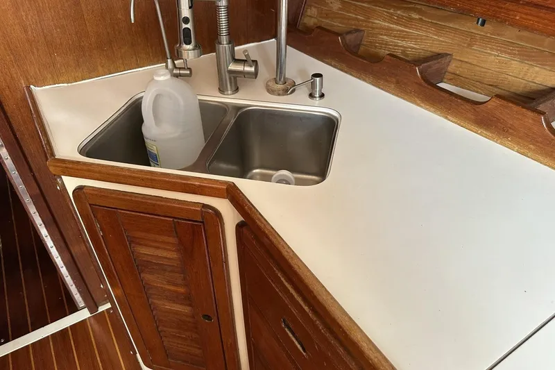 Slide: The Image of Galley sink area in a 1991 Catalina 42 sailboat with wooden cabinetry. - 53