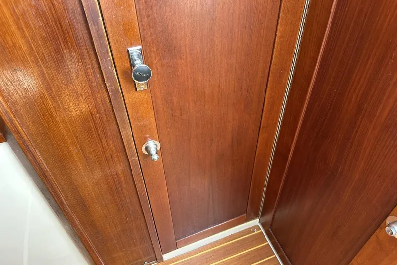 Slide: The Image of Wooden interior door on a 1991 Catalina 42 yacht, featuring a metal lock. - 62