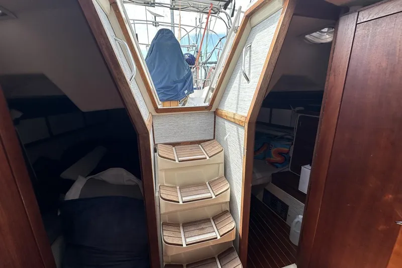 Slide: The Image of Interior of a 1991 Catalina 42 sailboat with wooden steps and cozy cabins. - 66