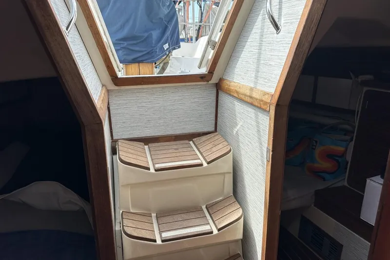 Slide: The Image of Interior view of a 1991 Catalina 42 sailboat with wooden steps and cabin access. - 67