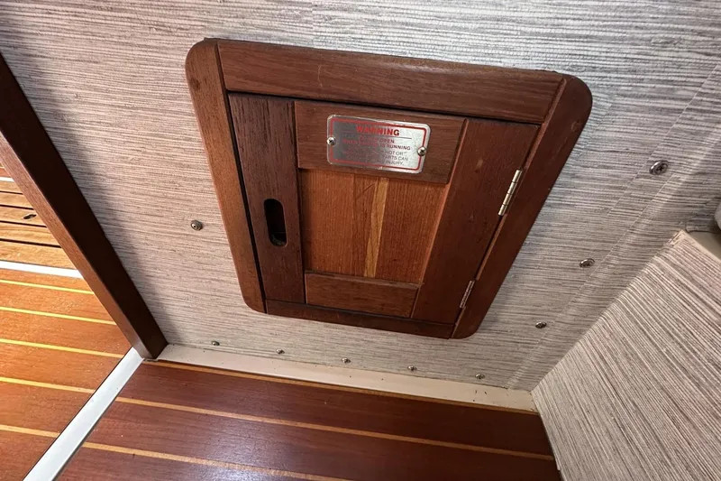 Slide: The Image of Wooden hatch door on 1991 Catalina 42 boat interior, featuring a warning sign. - 72