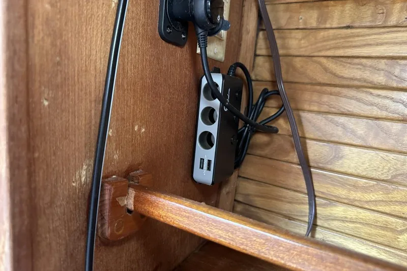Slide: The Image of Power strip and cables inside a 1991 Catalina 42 wooden interior. - 81