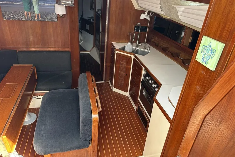 Slide: The Image of Interior of 1991 Catalina 42 sailboat with wooden furnishings and compact kitchen area. - 95