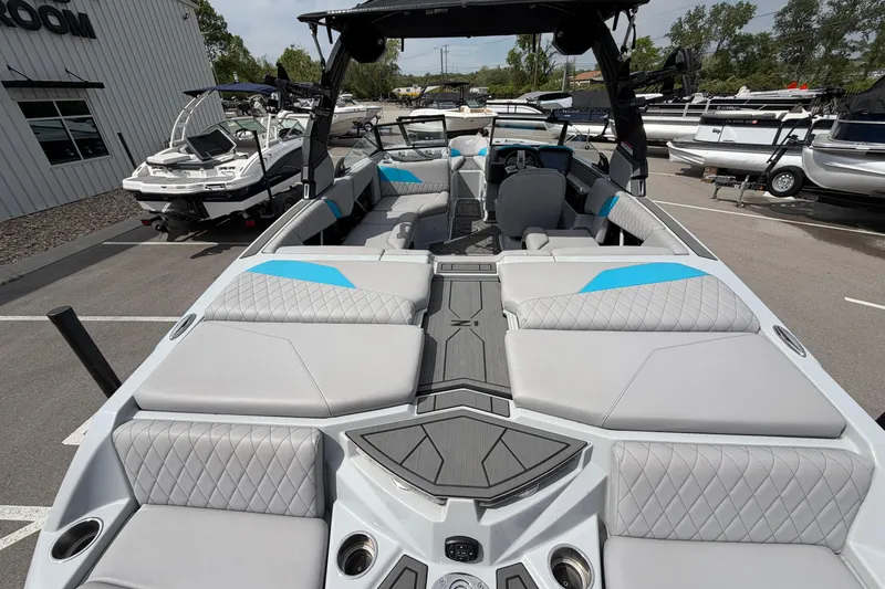 Slide: The Image of 2024 Tigé Z1 boat interior with gray and blue seating, parked outdoors. - 4