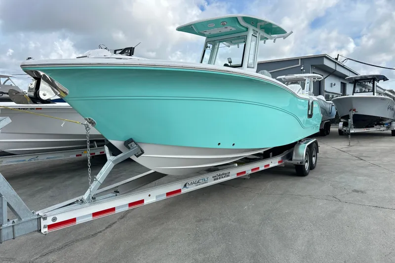 The Image of 2026 Sea Fox 268 Commander boat on trailer, turquoise hull, parked outdoors. - 1
