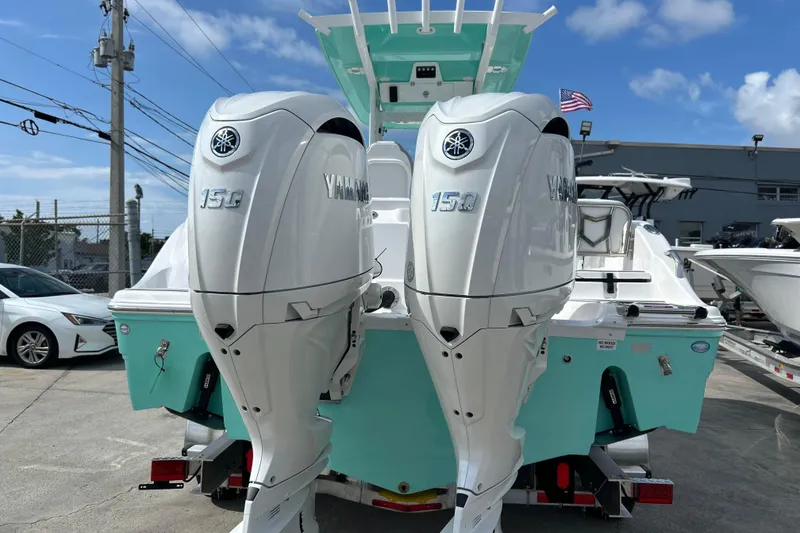 Slide: The Image of 2026 Sea Fox 268 Commander with twin Yamaha 150 engines, docked outdoors. - 24