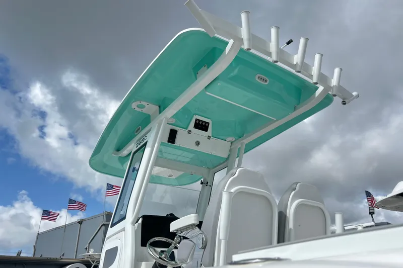 Slide: The Image of 2026 Sea Fox 268 Commander boat with teal canopy, under cloudy sky, American flags in background. - 5