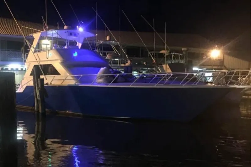 Slide: The Image of 1994 Breaux Bay Craft 58 Sportfish yacht docked at night, illuminated by soft lights. - 3