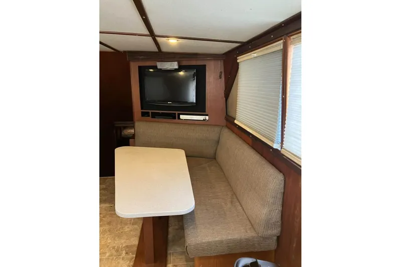 Slide: The Image of Interior of 1994 Breaux Bay Craft 58 Sportfish with TV, table, and seating area. - 8