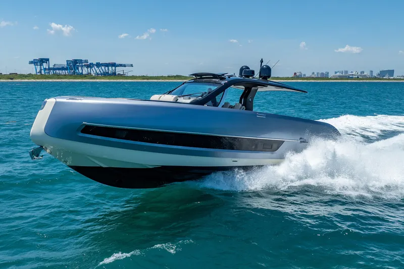 Slide: The Image of 2024 Invictus 460 yacht cruising on blue ocean near industrial port. - 19