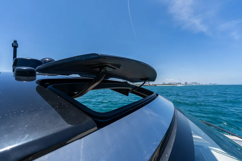 Slide: The Image of 2024 Invictus 460 yacht with open sunroof on a sunny day at sea. - 39