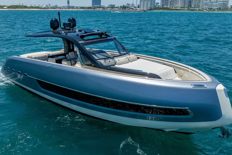 Slide: The Image of 2024 Invictus 460 yacht cruising on blue ocean near city skyline. - 6