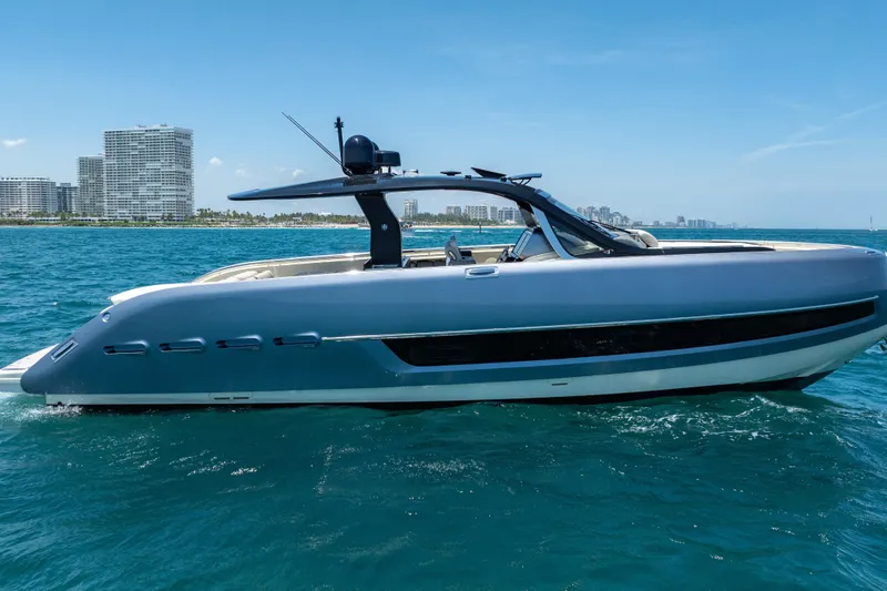 Slide: The Image of 2024 Invictus 460 yacht cruising on blue ocean with city skyline in background. - 7