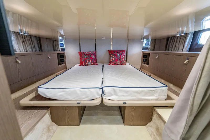 Slide: The Image of Luxurious 2024 Invictus 460 yacht cabin with twin beds and vibrant pillows. - 79